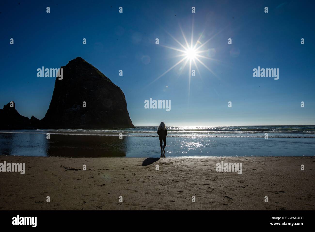 USA, Oregon, Silhouette einer Frau, die in der Nähe des Haystack Rock am Cannon Beach steht Stockfoto