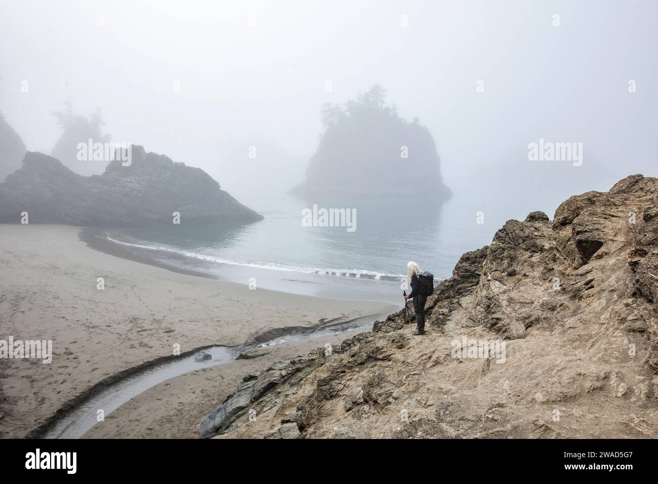 USA, Oregon, Brookings, Senior Frau, die auf der Düne über dem Strand steht Stockfoto