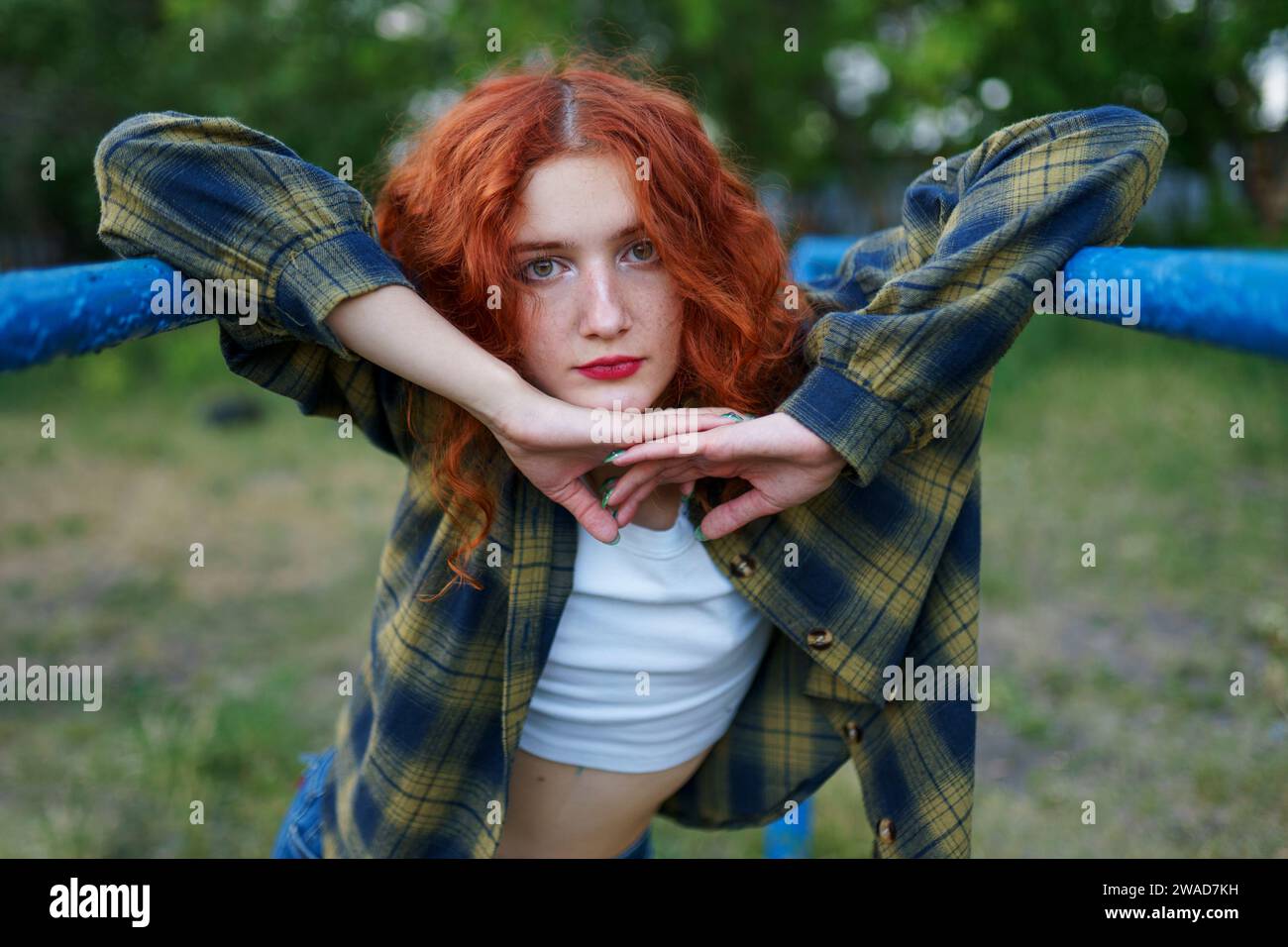 Rothaarige Frau posiert auf dem Spielplatz Stockfoto