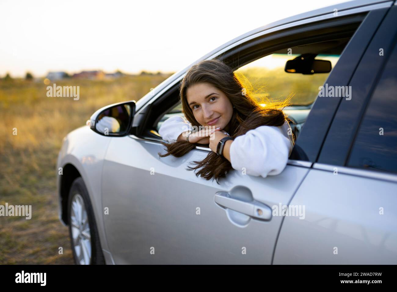 Porträt der jungen Frau, die durch Autofenster Stockfoto