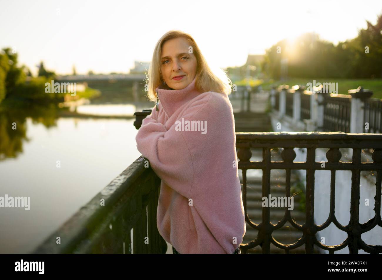 Porträt einer Reifen Frau, die bei Sonnenaufgang am Fluss steht Stockfoto