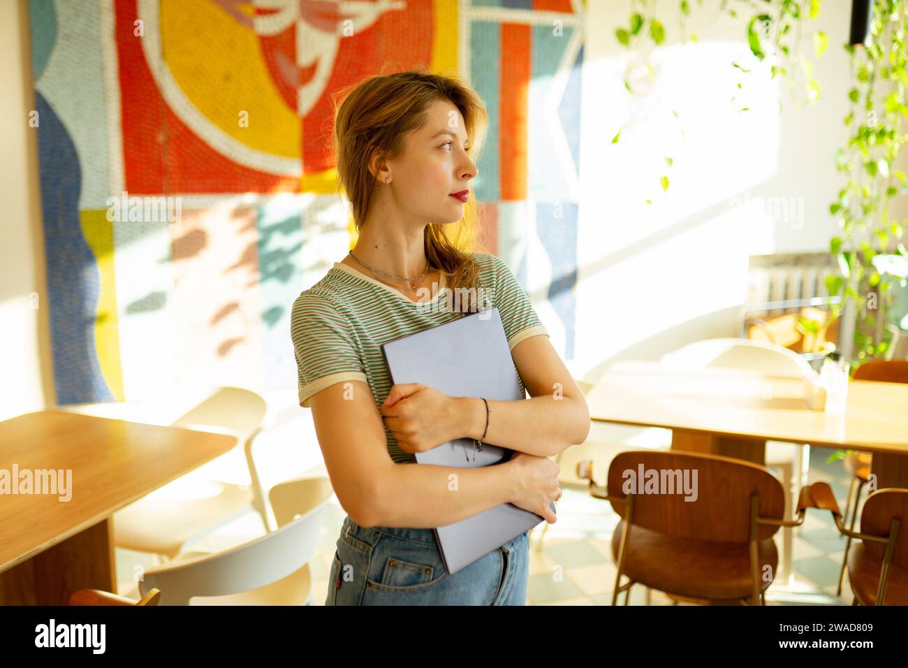 Porträt einer Frau, die mit Laptop im Café steht Stockfoto