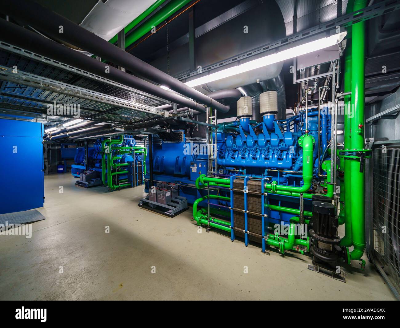 Offenbach, Deutschland. Dezember 2023. Diesel-Notstromgeneratoren im Untergeschoss Der Deutsche Wetterdienst (DWD) betreibt seit 1966 ein eigenes Computerzentrum. Das DWD-Mainframe-Rechenzentrum wird für die sehr rechenintensiven Wettervorhersagen genutzt und benötigt alle fünf bis sieben Jahre komplett neue Hochleistungs-Computersysteme. Darlegung: Andreas Arnold/dpa/Alamy Live News Stockfoto