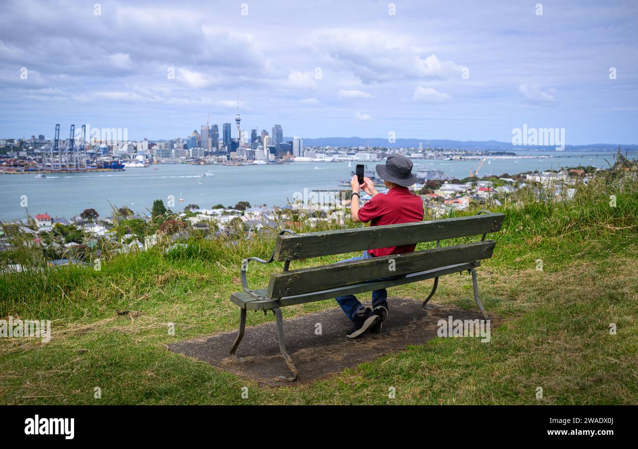 Touristen, die Fotos mit dem Smartphone vom Auckland Sky Tower und der Skyline machen. Mt Victoria, Devonport. Auckland. Stockfoto