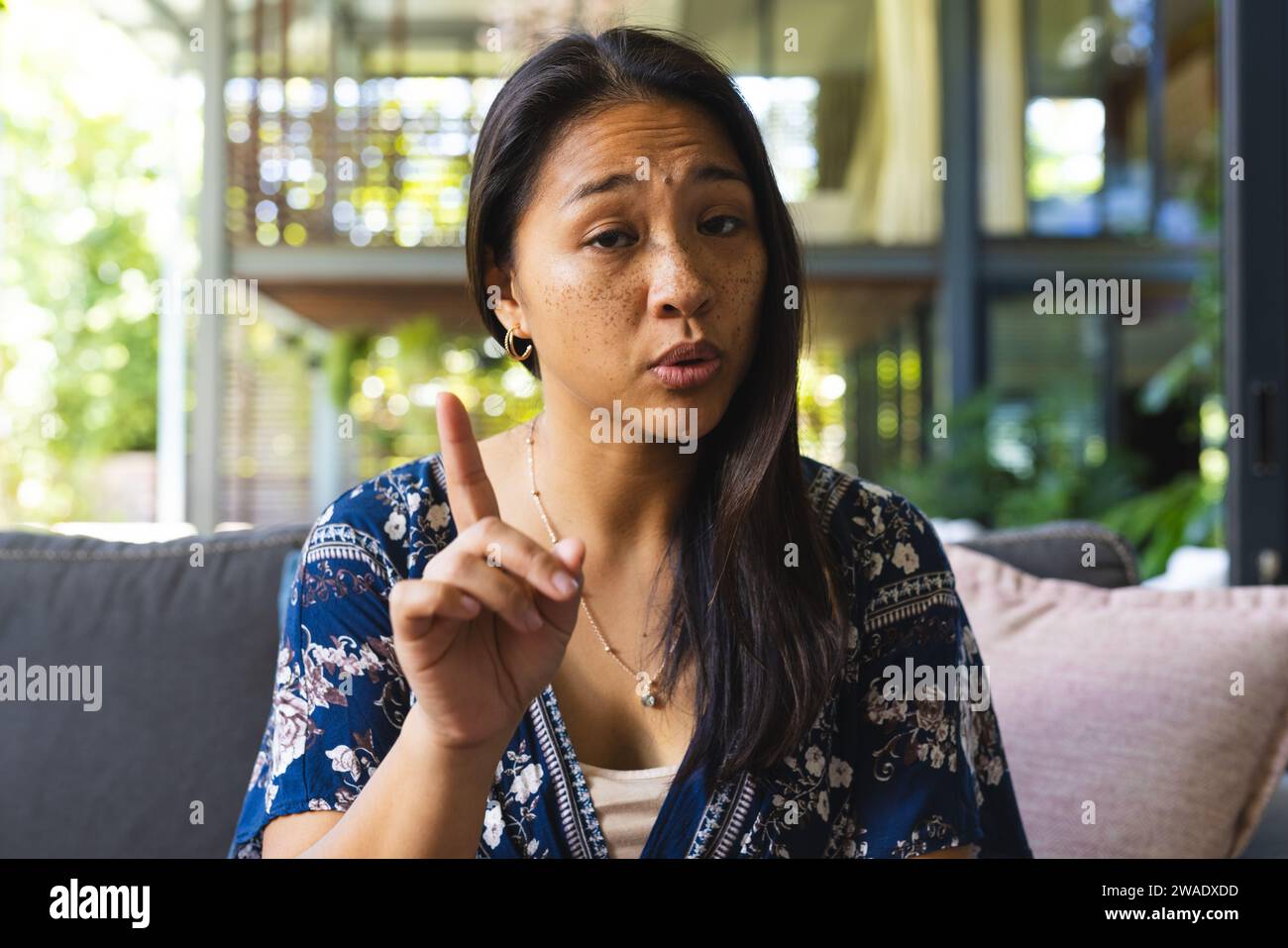 Porträt einer glücklichen asiatischen Frau mit langen Haaren, die zu Hause Videoanrufe macht. Leben, Technologie und Lebensstil, unverändert. Stockfoto