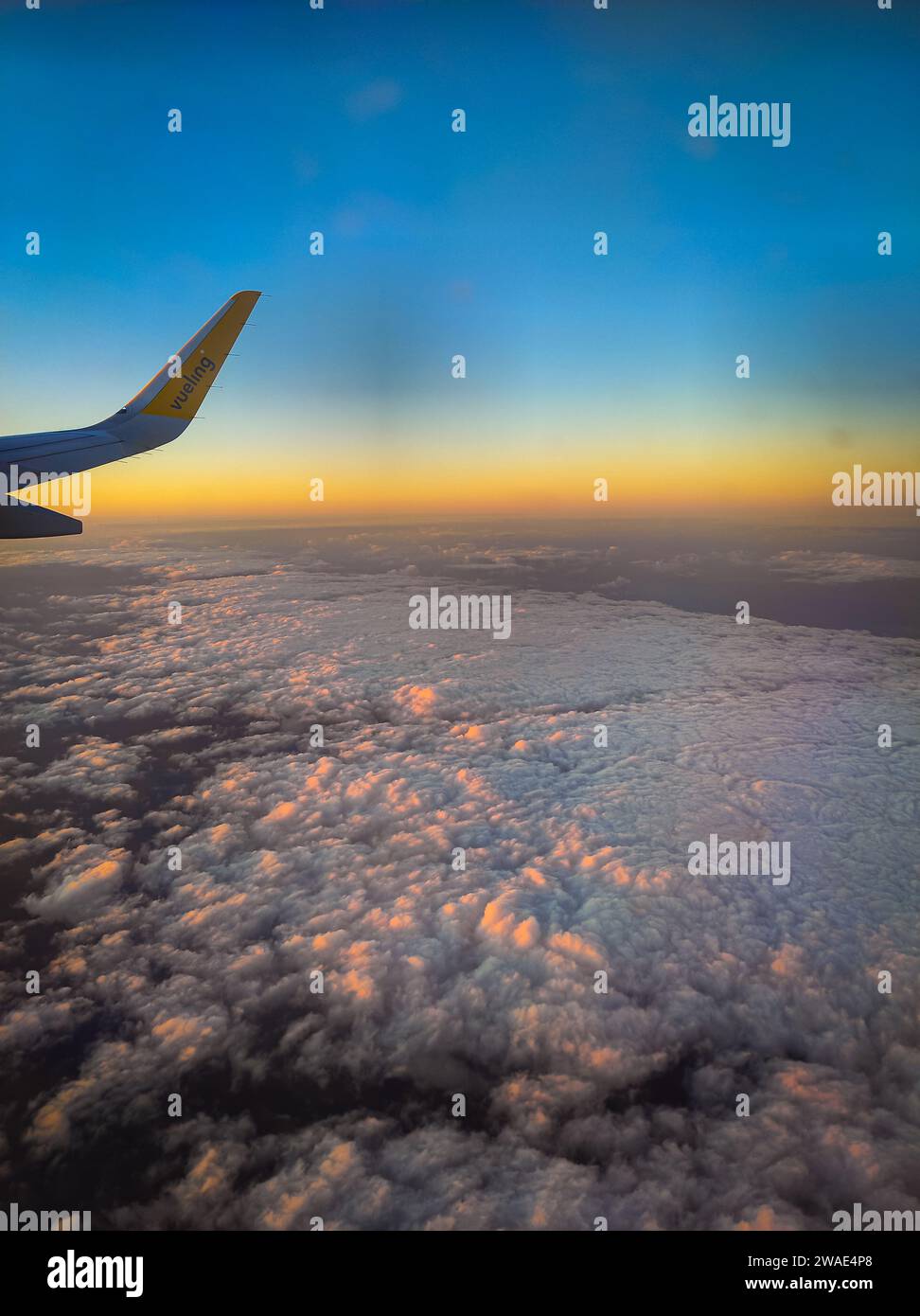 Ein malerischer Blick auf eine wunderschöne Atmosphäre des Sonnenuntergangs in einem bewölkten Himmel von einem Flugzeug aus Stockfoto