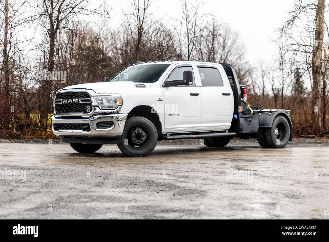 Ein großer Lkw wird mit einem großen Bettrahmen und verschiedenen anderen Ausrüstungsteilen befüllt Stockfoto