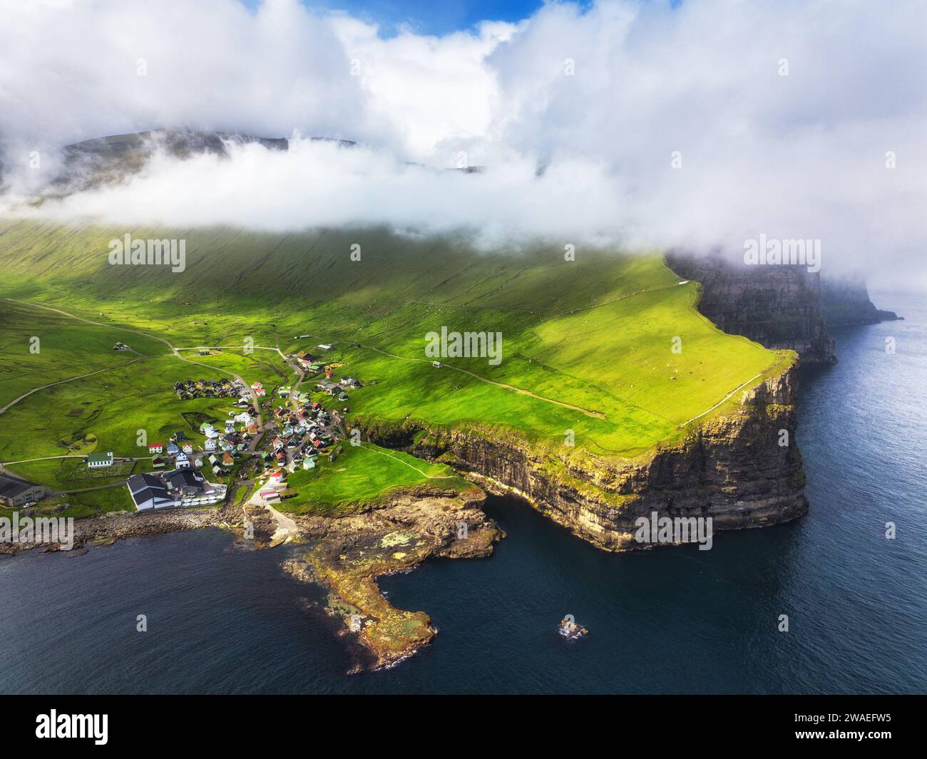 Färöer-Inseln - Panoramablick aus der Vogelperspektive auf das Dorf Gjogv auf Klippen, die vom Ozean gespült werden, auf die Insel Eysturoy, Dänemark, Europa Stockfoto