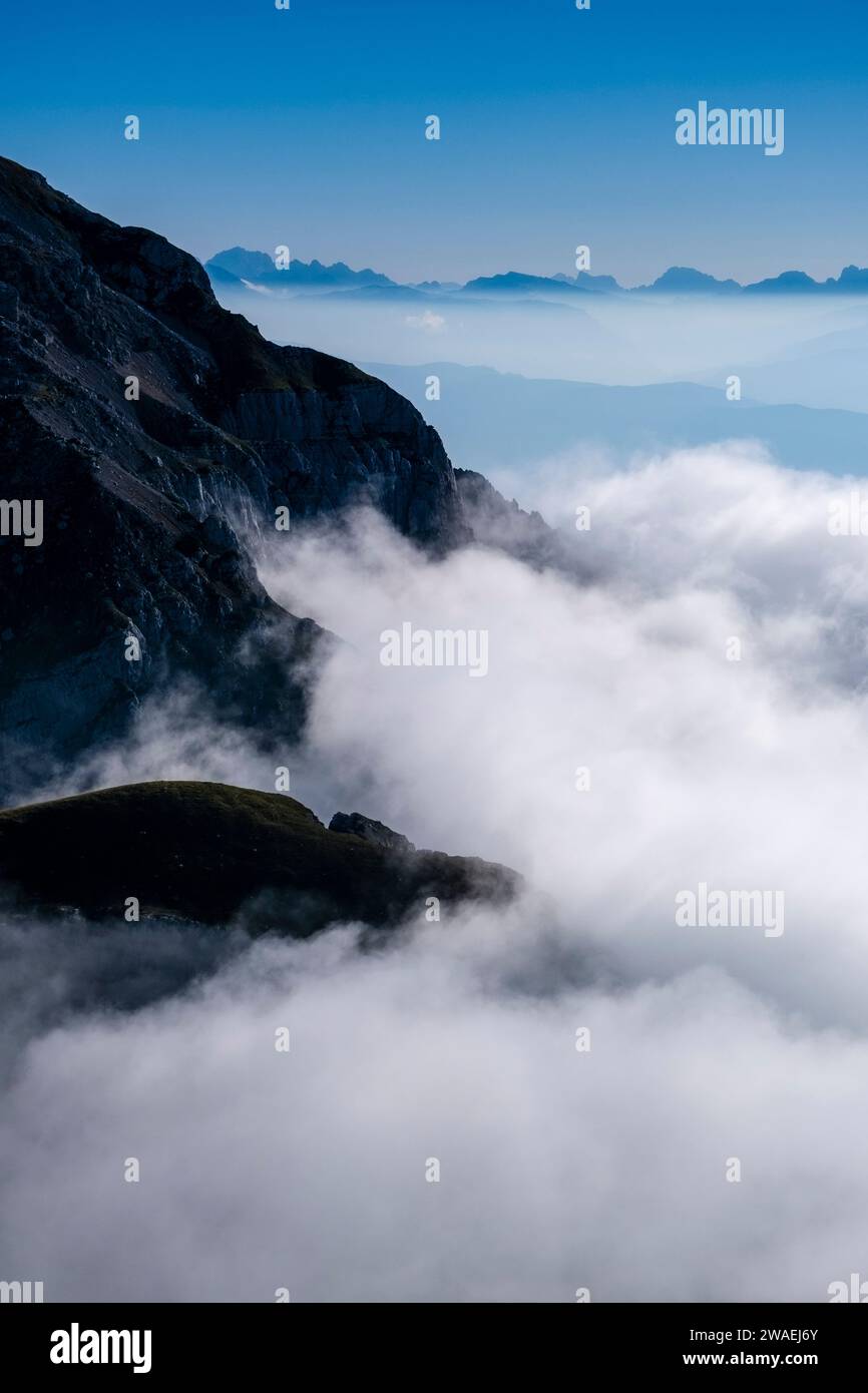 Klippen und Bergrücken des Piz Galin ragen aus den Wolken hervor, vom Gipfel des Croz dell'Altissimo aus gesehen. Stockfoto