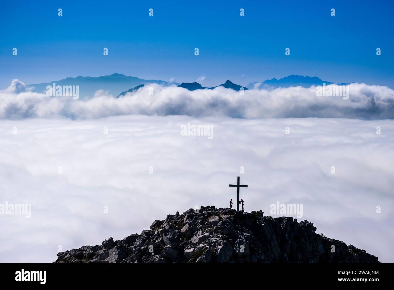 Das Tal von Molveno bedeckt mit Wolken, der Gipfel des Croz dell'Altissimo mit zwei Alpinisten, die aus den Wolken ragen, vom Gipfel des CI aus gesehen Stockfoto