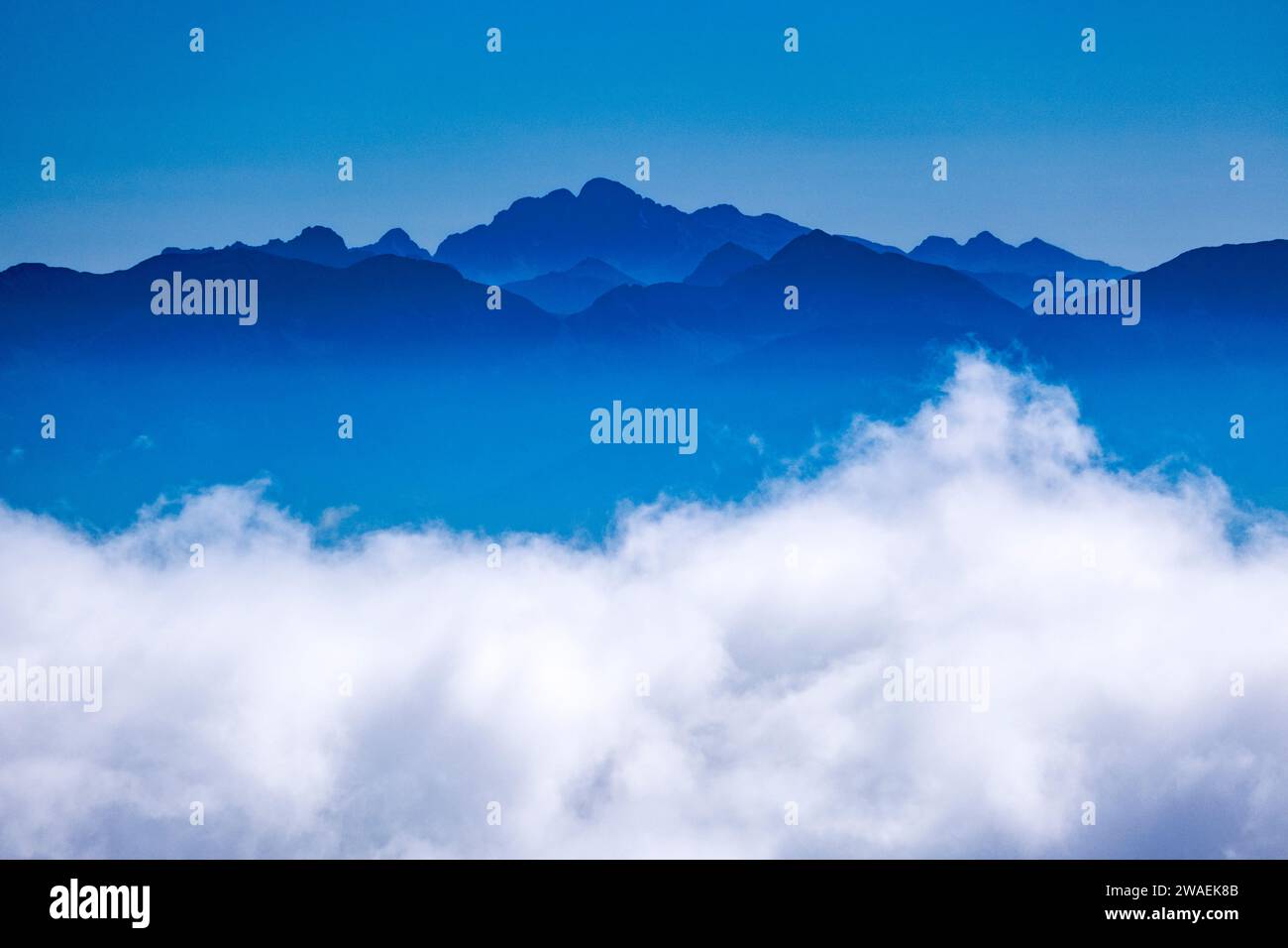 Silhouetten der Gipfel und Bergrücken der Dolomiten, die aus den Wolken ragen, vom Gipfel des Croz dell'Altissimo aus gesehen. Stockfoto