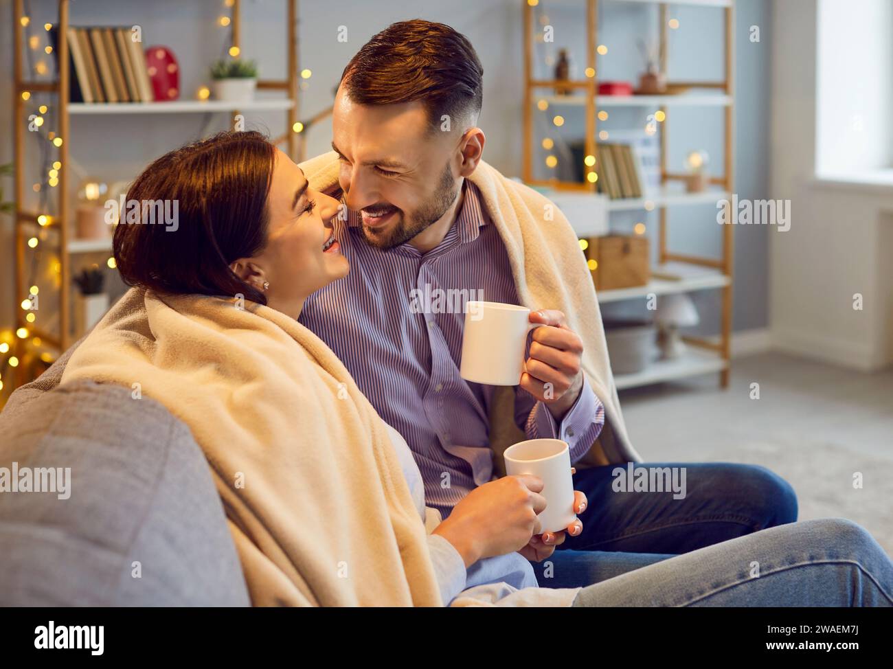 Glückliches Paar, das heiße Schokolade zu Hause genießt Stockfoto