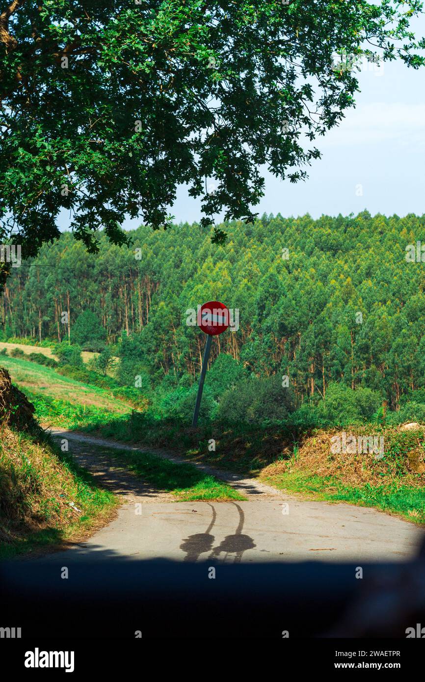 Eine idyllische ländliche Landschaft mit einer Straße und einem Stoppschild in Asturien, Spanien Stockfoto