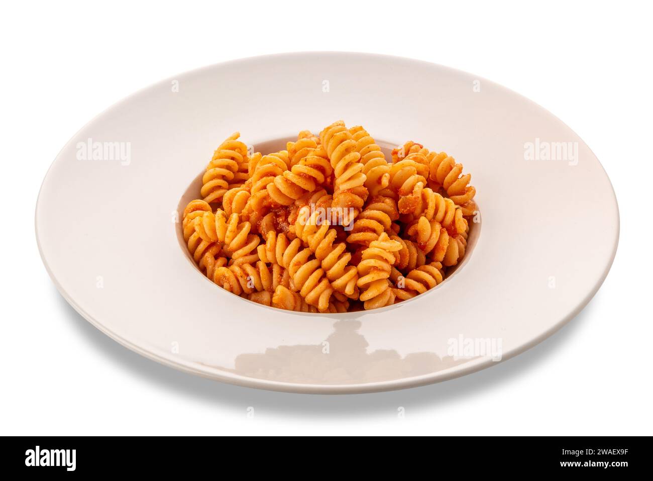 Nudeln Fusilli Makkaroni mit Tomatensauce in weißer Platte isoliert auf weiß mit Schnittpfad enthalten Stockfoto