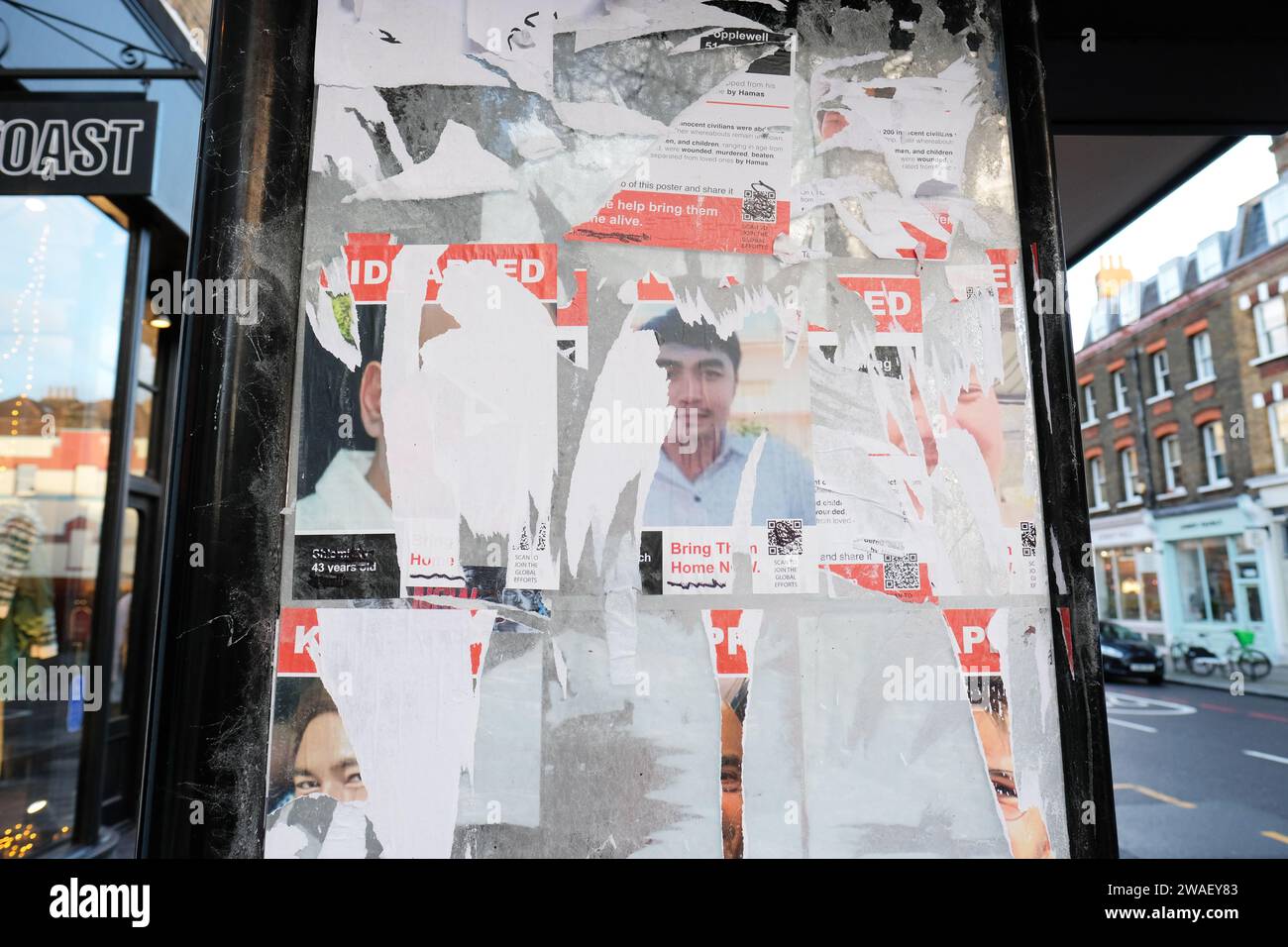 Islington London - zerrissene Plakate, die entführte israelische Opfer des Angriffs der Hamas am 7. Oktober 2023 auf eine Telefonbox im Norden Londons zeigen - aufgenommen im Januar Stockfoto