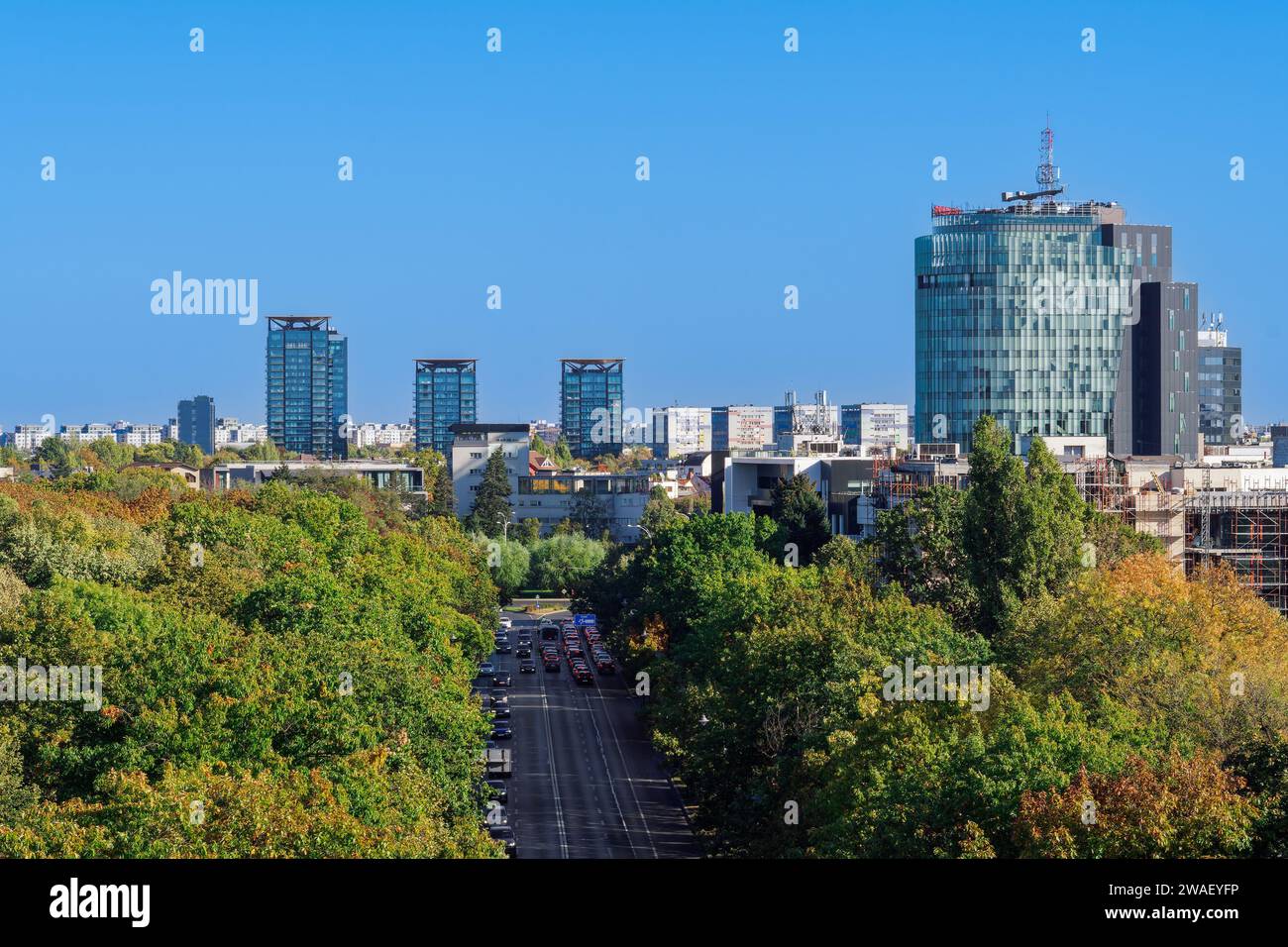 Bukarest, Rumänien Panoramablick auf die Stadt vom Triumphbogen mit Park und modernen Gebäuden im Hintergrund unter einem klaren blauen Himmel. Stockfoto