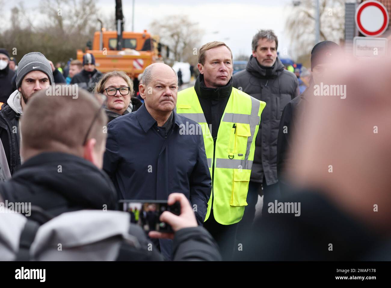 Sangerhausen, Deutschland. Januar 2024. Bundeskanzler Olaf Scholz (M, SPD) und Sven Vogler (Gelbweste), Leiter des Katastrophenschutzes Mansfeld-Südharz, besuchen Orte in Sangerhausen, die von Überschwemmungen betroffen sind. Am selben Tag besuchen Bundeskanzler Scholz und Sachsen-Anhalters Ministerpräsident Haseloff das Hochwassergebiet rund um die Helme und sprechen mit Freiwilligen. Quelle: Jan Woitas/dpa/Alamy Live News Stockfoto