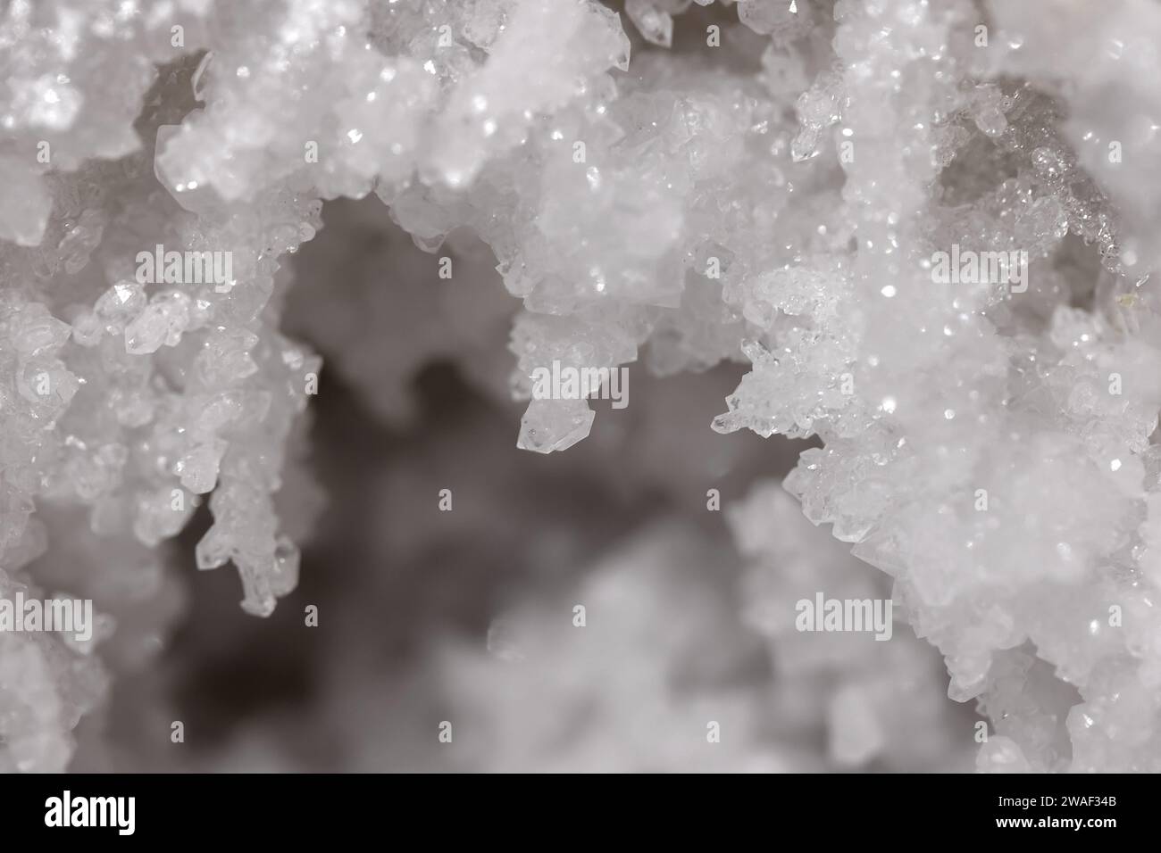 Nahaufnahme eines Makros einer weißen Kristallformation im Detail mit geringer Schärfentiefe, Hintergrund Stockfoto