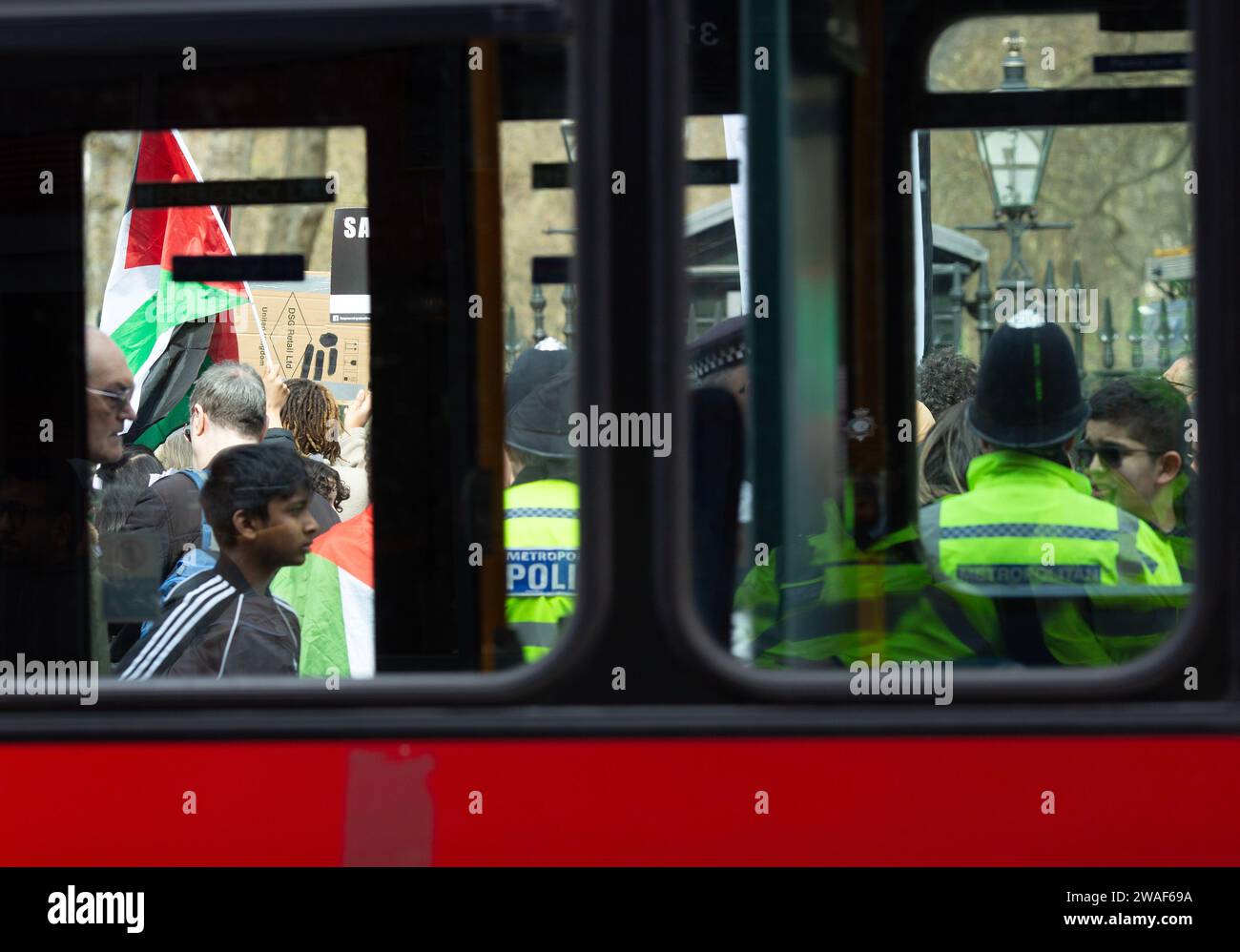 Pro-palästinensische Demonstranten versammeln sich mit Fahnen und Plakaten bei einem Protest vor den Toren der israelischen Botschaft in London. Stockfoto