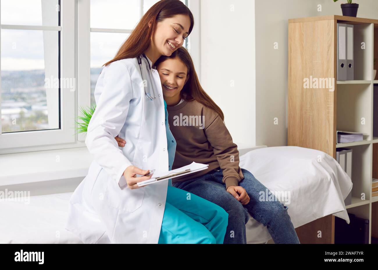 Nette und niedliche Krankenschwester unterstützt Teenager Mädchen Patienten vor der medizinischen Untersuchung. Stockfoto