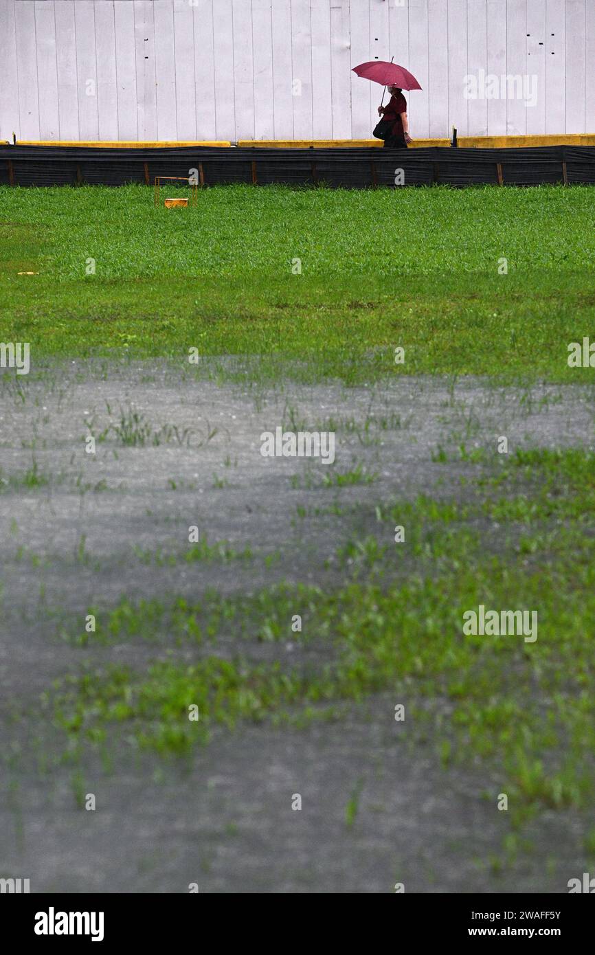 Singapur. Januar 2024. Eine Person, die einen Schirm hält, läuft im Regen in Singapur, 4. Januar 2024. Quelle: Dann Chih Wey/Xinhua/Alamy Live News Stockfoto