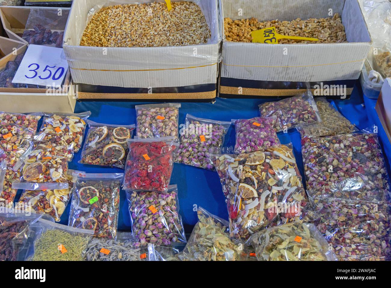 Loser Tee mit Früchten und Kräuterblättern in Taschen und Nüsse in Kisten auf dem Markt Stockfoto