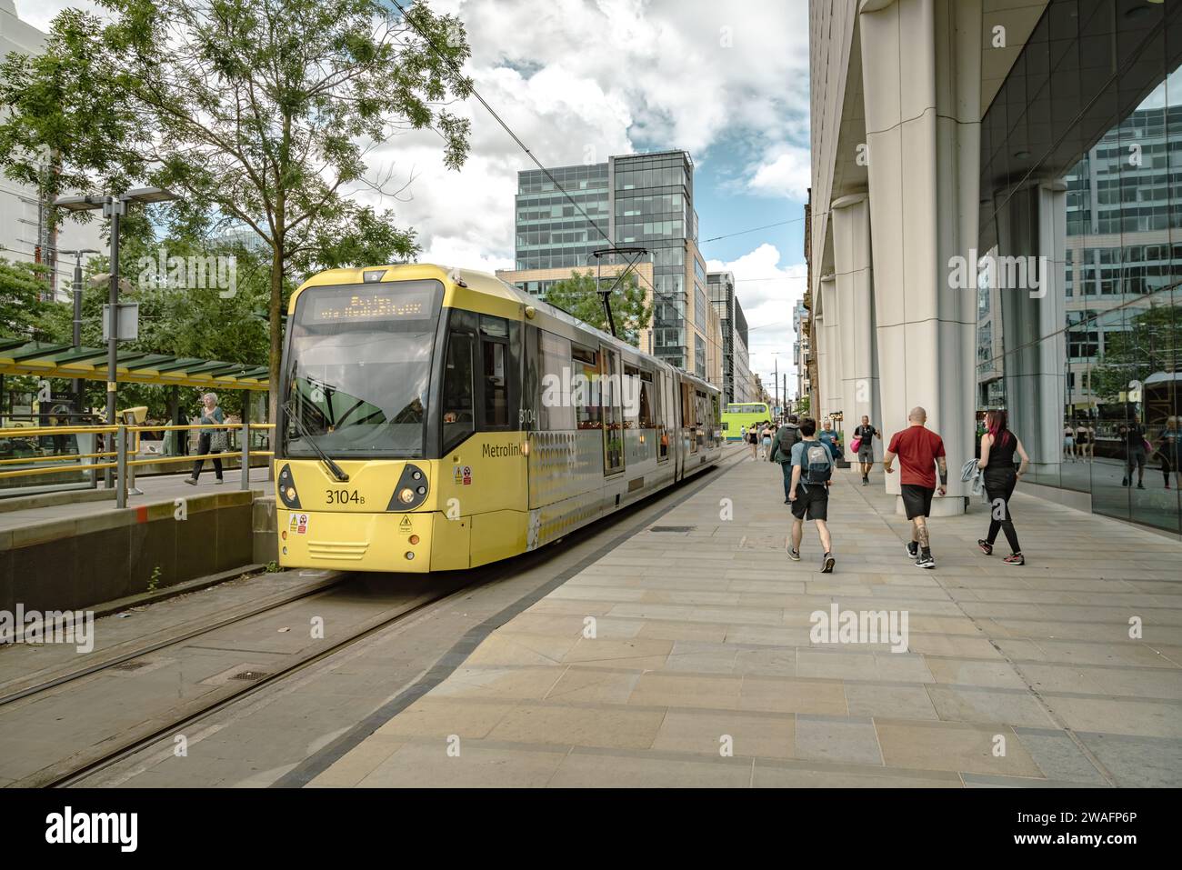 Eine Metrolink-Straßenbahn, die durch das dynamische Stadtzentrum von Manchester fährt, Ein schnelles und umweltfreundlicheres öffentliches Verkehrsmittel. Stockfoto