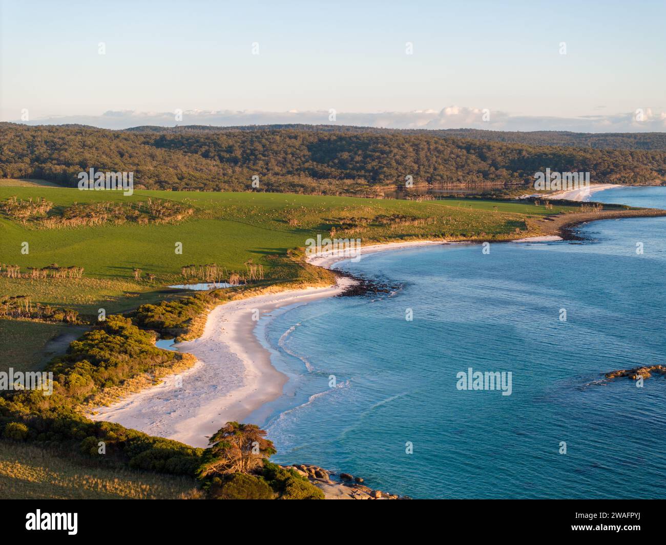 Ein Luftbild von einem atemberaubenden Strand mit kristallblauem Meer und grünen Hügeln Stockfoto