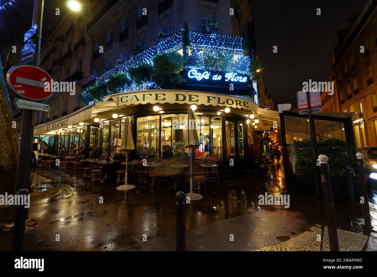 Paris, Frankreich - 31. Dezember 2023: Restaurant Cafe de Flore bei regnerischer Nacht. Es liegt in Saint Germain des Pres während der Weihnachtszeit in Pari Stockfoto