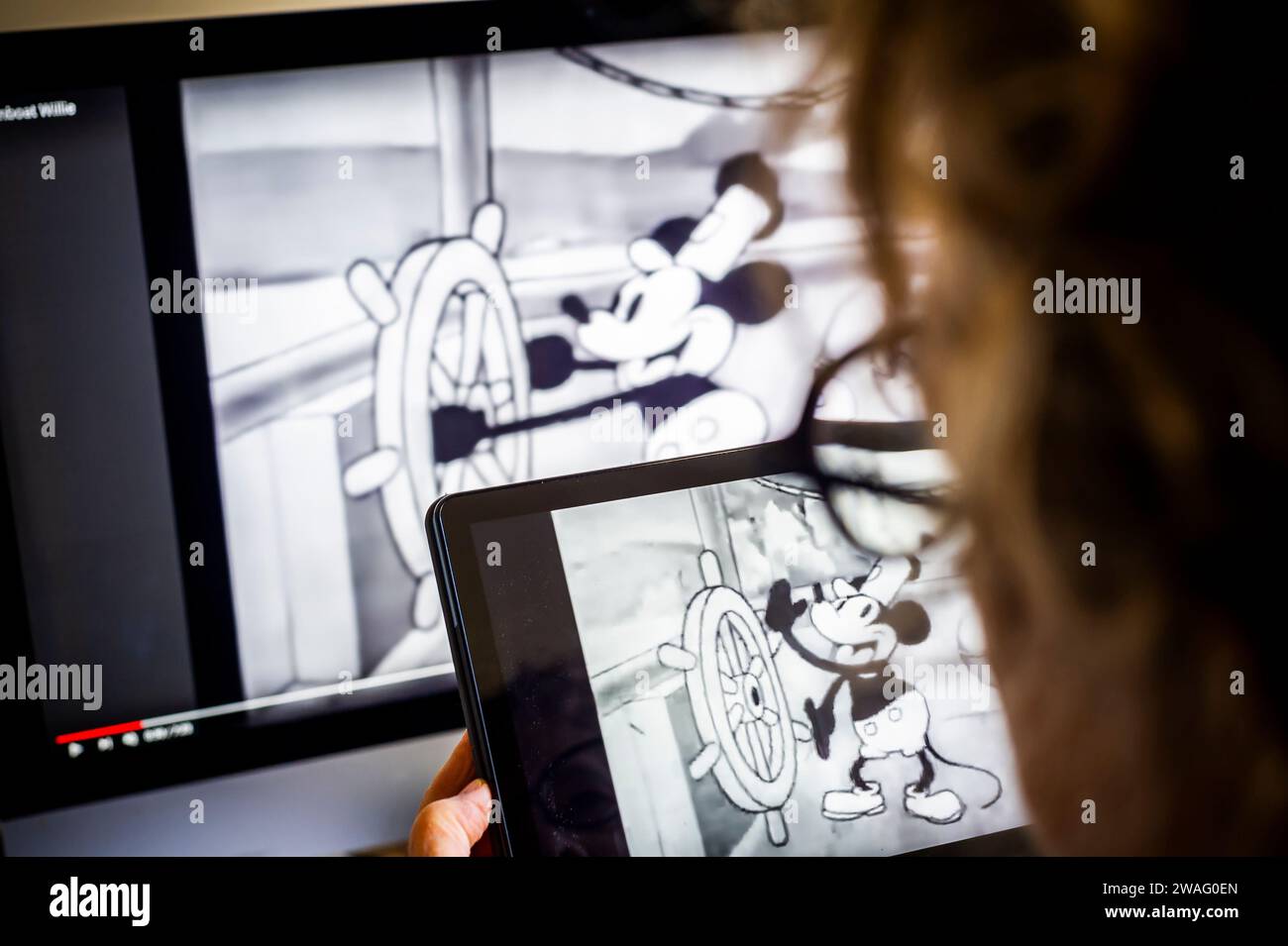 Eine Frau sieht sich am Dienstag, den 2. Januar 2024, den Cartoon „Steamboat Willie“ der Walt Disney Co. In New York an. Steamboat Willie, die Originalversion der ikonischen Mickey Maus, ist mit dem Auslaufen des Urheberrechtsschutzes in diesem Jahr öffentlich bekannt geworden. (© Richard B. Levine) Stockfoto