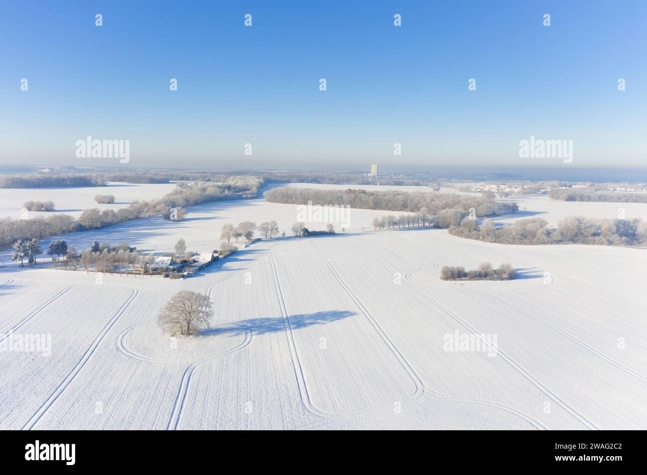 Blick aus der Vogelperspektive über ländliche Landschaft mit Feldern und Wiesen, umgeben von Bäumen und Hecken, die im Winter mit Schnee bedeckt sind, Schleswig-Holstein, Deutschland Stockfoto