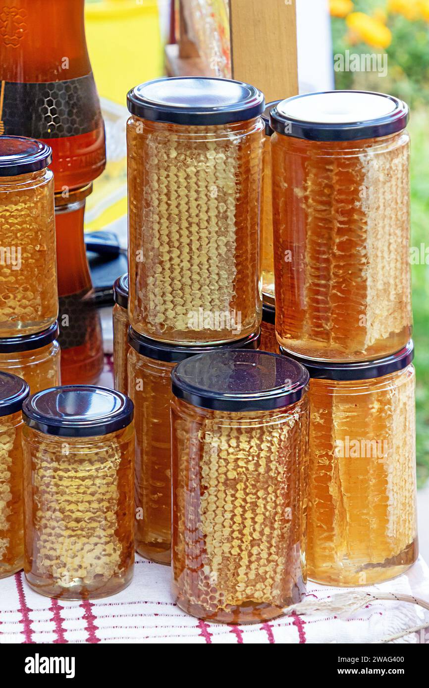 Bio-Honigkamm und andere gesunde natürliche Lebensmittel in Glasgläsern verkauft draußen auf einem Markt Stockfoto
