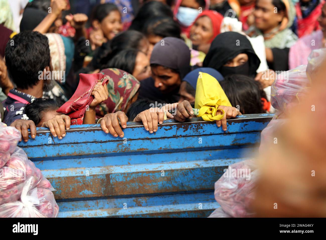 Dhaka, Wari, Bangladesch. Januar 2024. Am 4. Januar 2024 warten die Menschen in der Schlange, um bei einer Trading Corporation of Bangladesh (TCB) in Dhaka tägliche Essentials zu subventionierten Preisen zu kaufen. Die Regierung hat ein Programm zum Verkauf von Grundkapital zu subventionierten Zinssätzen für Familien mit niedrigem Einkommen gestartet. (Kreditbild: © Habibur Rahman/ZUMA Press Wire) NUR REDAKTIONELLE VERWENDUNG! Nicht für kommerzielle ZWECKE! Stockfoto