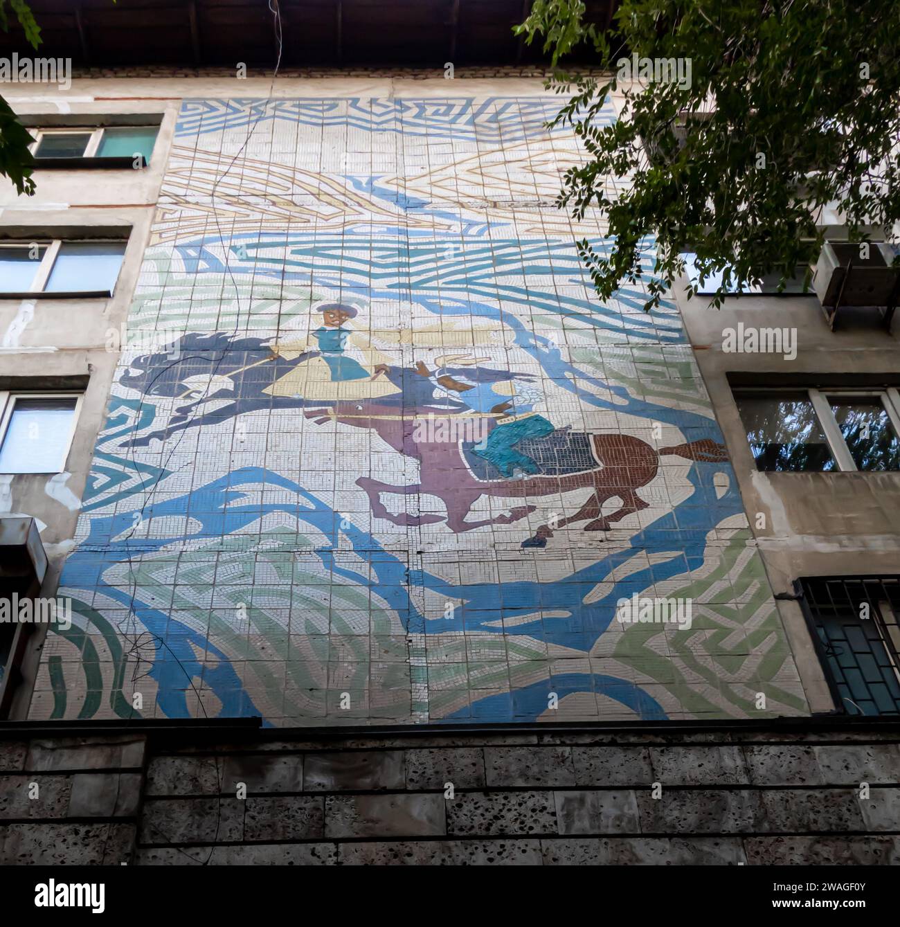 Ein Mosaik mit einem traditionellen kasachischen Thema - Kampf auf Pferden, Krieger in traditioneller Kleidung. 1968. Almaty Kasachstan Stockfoto