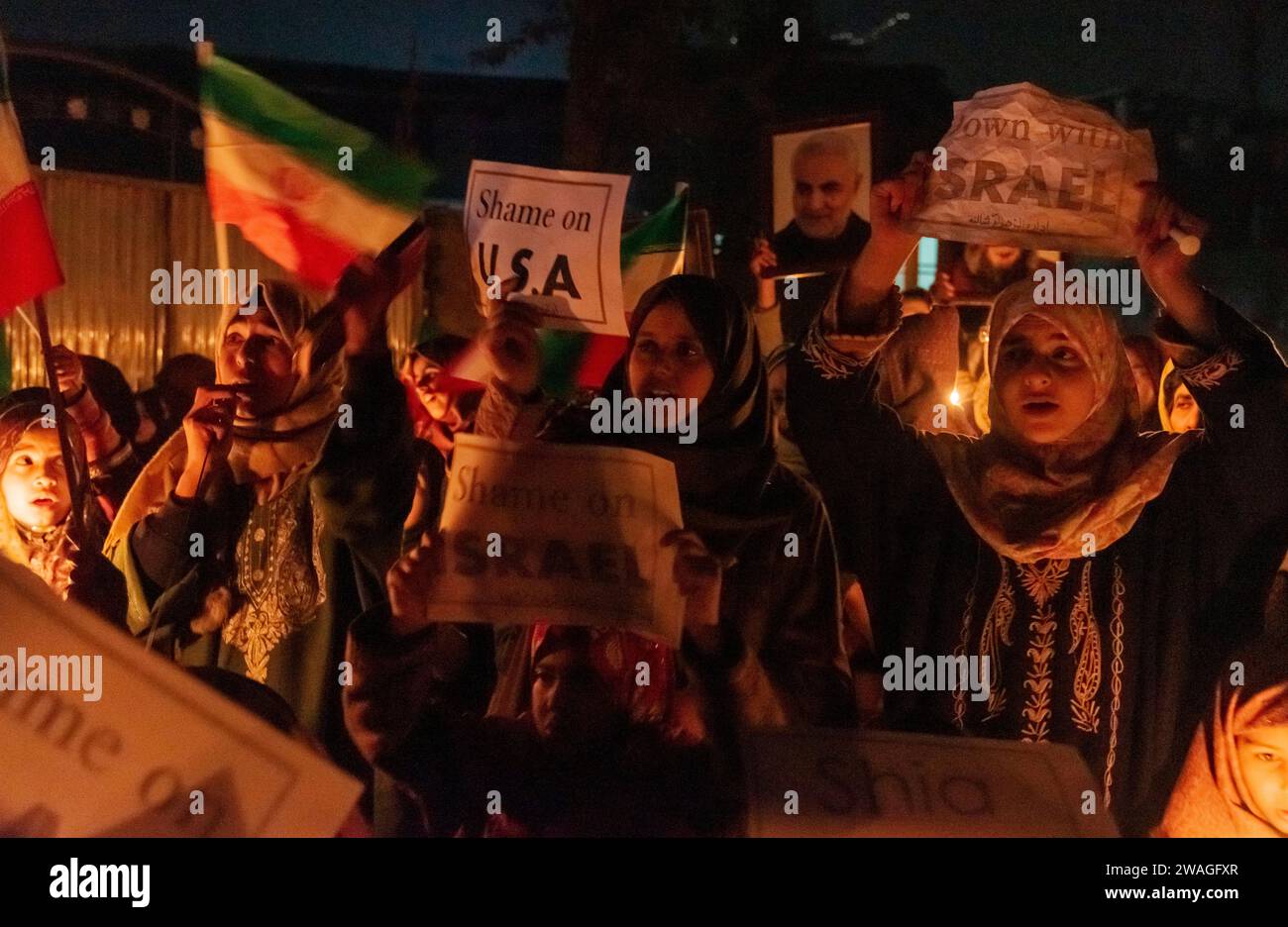 Srinagar, Indien, 01.04.2024, Kaschmir schiitische Muslime halten Plakate, während sie während einer Mahnwache bei Kerzenlicht Anti-Israel- und Anti-USA-Parolen rufen. Am Rande von Srinagar, Kaschmir, hielten schiitische Muslime aus der kaschmirischen Gemeinde eine Mahnwache bei Kerzenlicht ab, in der sie ihren Widerstand gegen Israel und die Vereinigten Staaten zum Ausdruck brachten. Die feierliche Versammlung nahm eine tragische Wende, als 84 Personen ihr Leben verloren und zahlreiche andere während einer Zeremonie zum Gedenken an den Tod des iranischen Generals Qassem Soleimani in einer Explosion verletzt wurden. Der Islamische Staat übernahm die Verantwortung für die beiden zerstörerischen Explosionen, die sich daraus ergaben Stockfoto