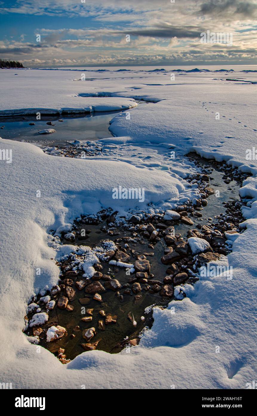 Die Öffnungen im Eis und im Schnee in der Nähe der Küste von Newport Nay stammen von einem Frühling, der das ganze Jahr über fließt, Newport State Park, Door County, Wisconsin Stockfoto