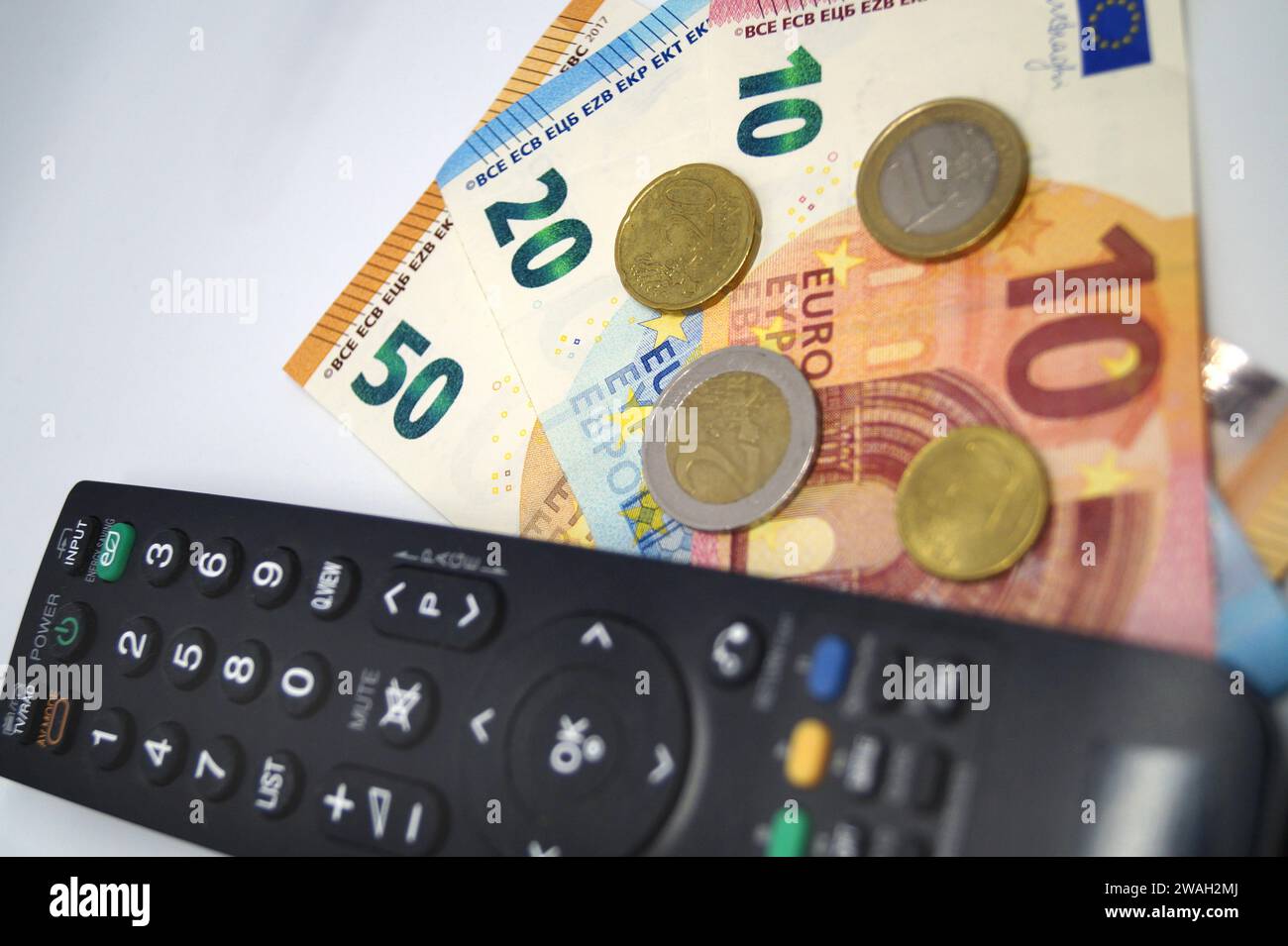 Fernbedienung und Geld, Symbolbild des Pay-TV Stockfoto