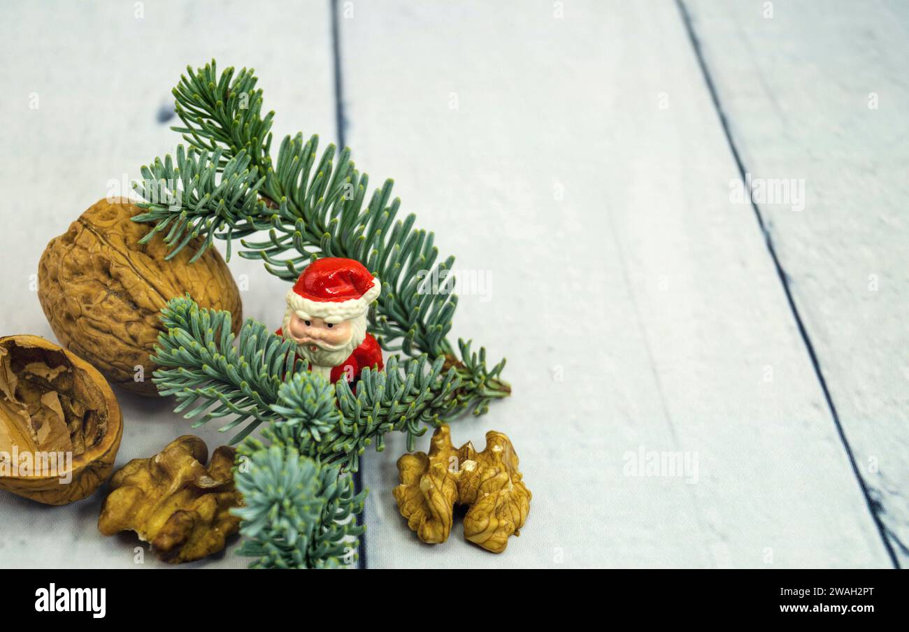 Walnüsse, Tannenzweig und Weihnachtsfigur, symbolisches Weihnachtsbild Stockfoto