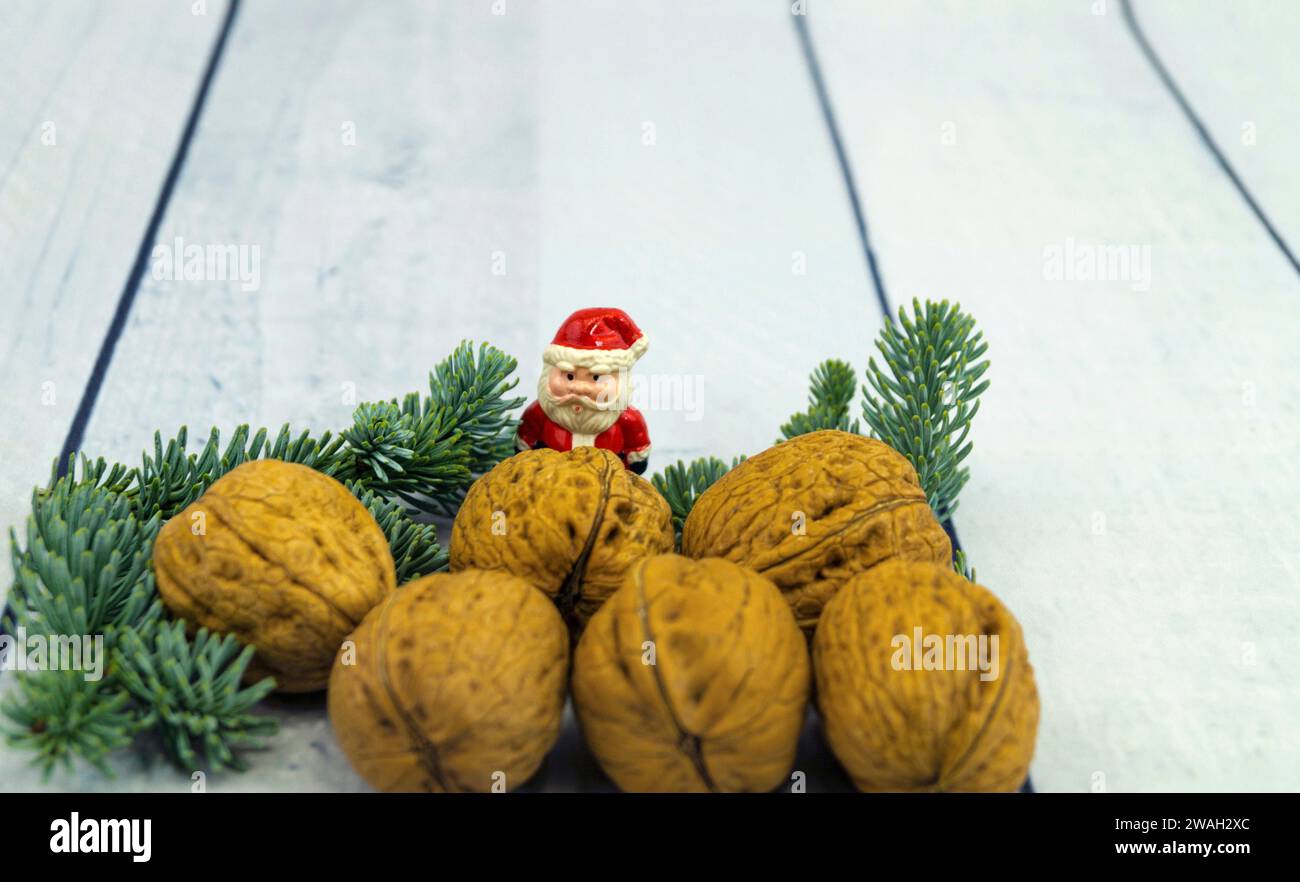 Walnüsse, Tannenzweig und Weihnachtsfigur, symbolisches Weihnachtsbild Stockfoto