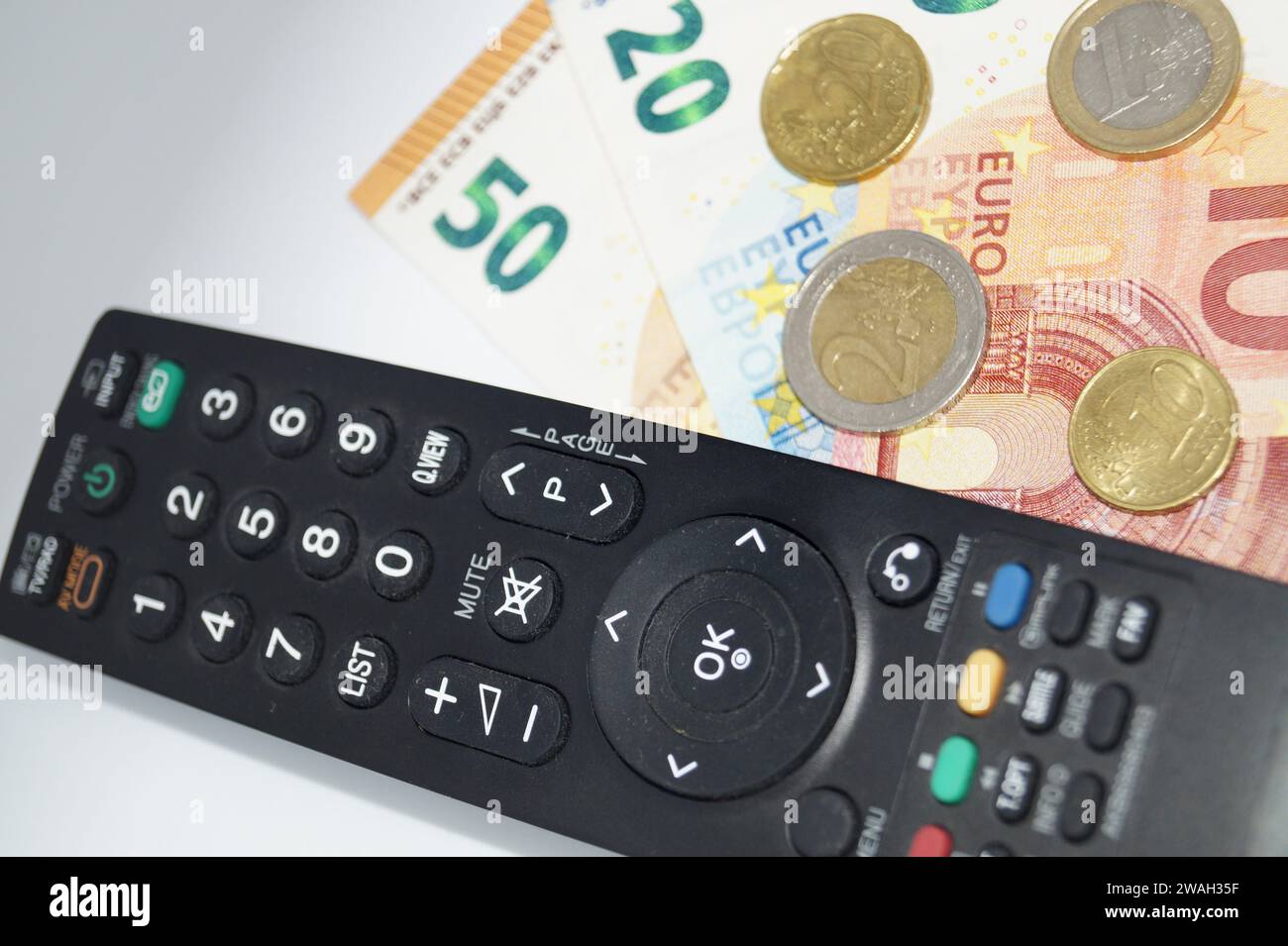 Fernbedienung und Geld, Symbolbild des Pay-TV Stockfoto
