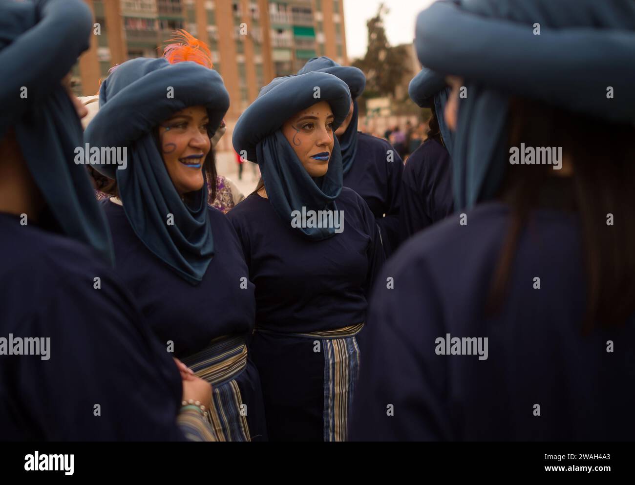 Malaga, Spanien. Januar 2024. Frauen in schwarzen Kostümen wurden vor der traditionellen Epiphany-Parade im Bezirk Cruz de Humilladero beim Gespräch gesehen. Die Viertel von Malaga feiern die traditionellen Epiphany-Paraden in der Stadt, indem sie Süßigkeiten werfen oder Kindern Geschenke schenken, in Anwesenheit von Tausenden von Menschen. Quelle: SOPA Images Limited/Alamy Live News Stockfoto