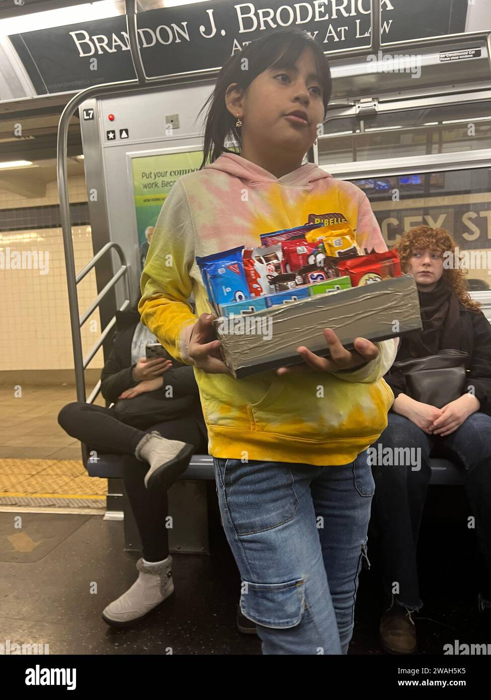 Ein Kind aus einer Familie ohne Papiere verkauft Süßigkeiten in einer New York City U-Bahn. Stockfoto
