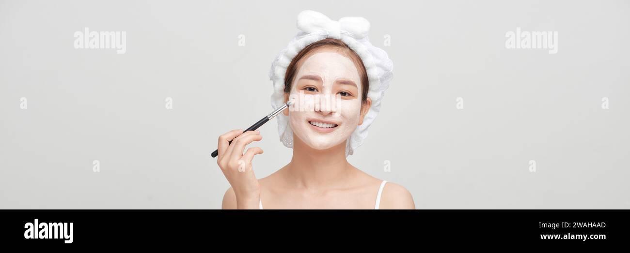 Spa-Mädchen, das Gesichtsmaske aufträgt. Schönheitsbehandlungen. Panorama Stockfoto