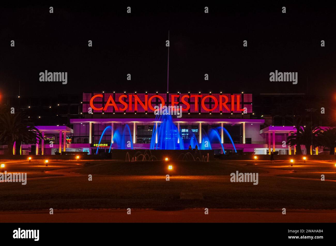Fassade des Casino Estoril bei Nacht in Estoril City, nahe Lissabon, Portugal. Eines der größten Kasinos in Europa, das sich mehrheitlich im Besitz von Dr. Stanley Ho befindet. Stockfoto