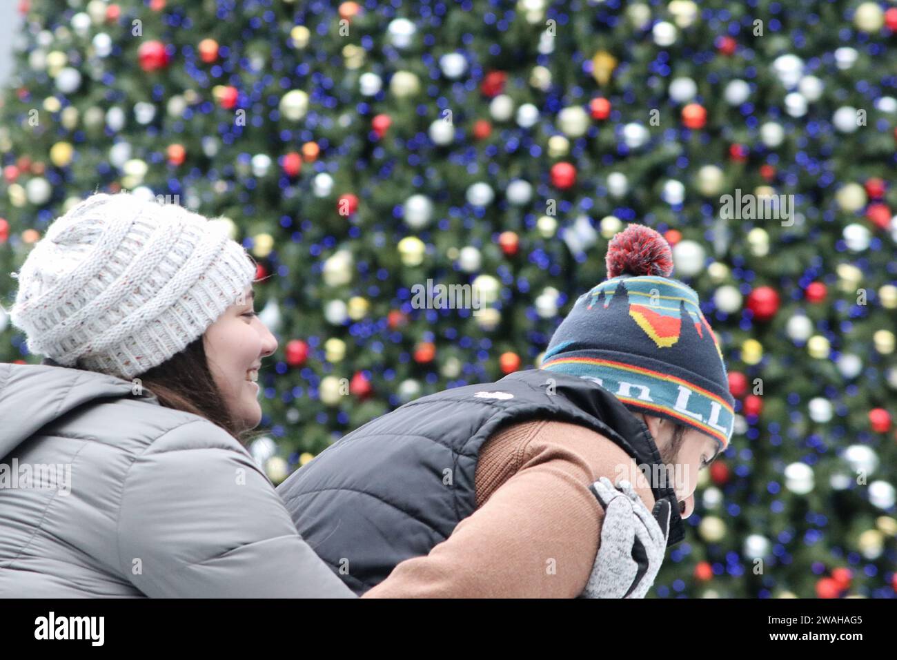 In der PPG Ice Skating Arena in Pittsburgh, PA, spielt ein Paar in Winterkleidung und Hüten auf dem Eis Stockfoto