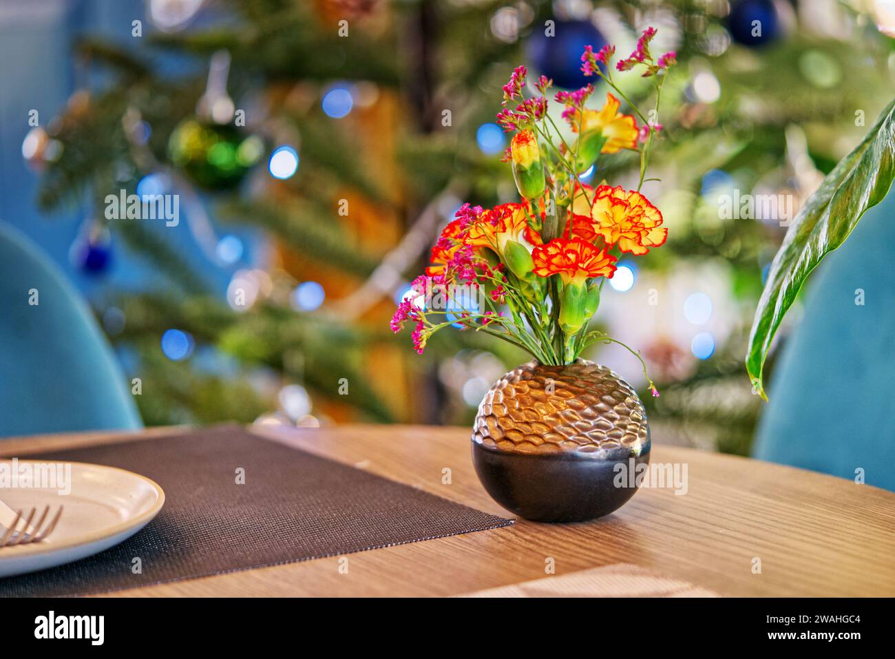 Bunte Blumen in runder Vase auf einem Tisch im Restaurant mit Platz für Kopie, Landschaftsbild mit Bokeh-Hintergrund. Stockfoto