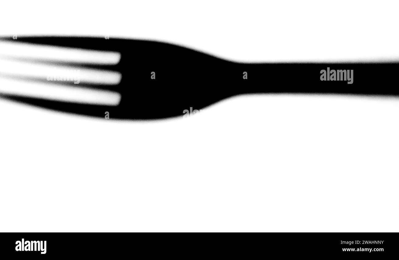 Schwarz-weiß des Schattens der Essensgabel isoliert auf weißem Hintergrund Stockfoto