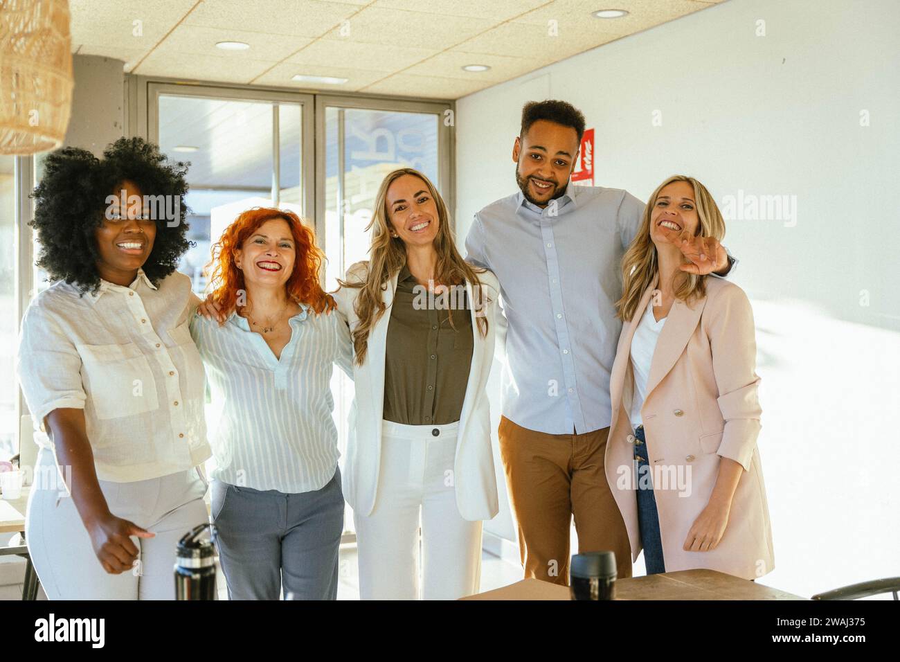 Eine Gruppe verschiedener Geschäftsleute lächelt, während sie sich im Büro posiert. Geschäftskonzept. Stockfoto