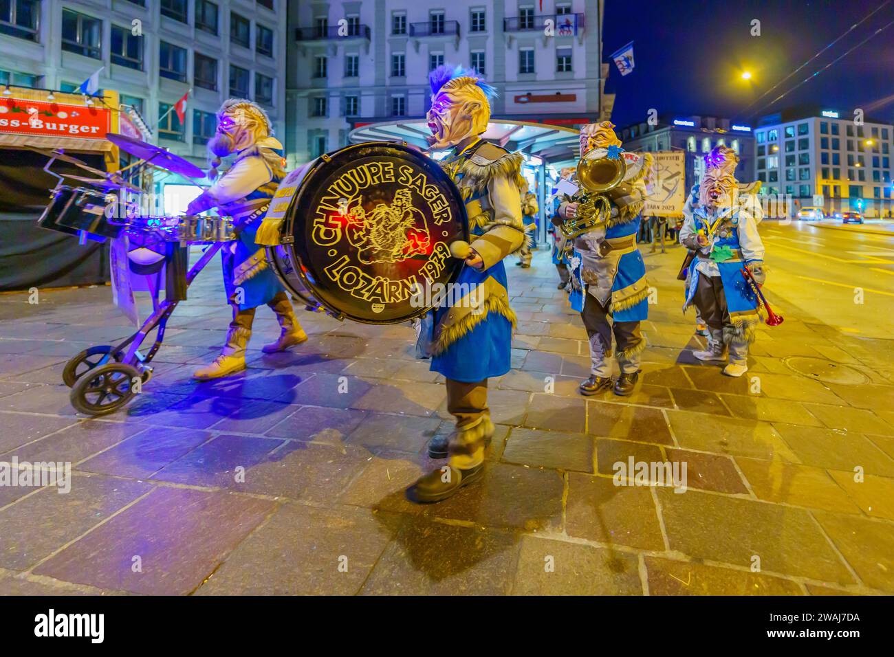 Luzern, Schweiz - 20. Februar 2023: Musiker in Kostümen marschieren auf den Straßen, Teil einer frühmorgendlichen Parade des Fasnacht-Karnevals Stockfoto