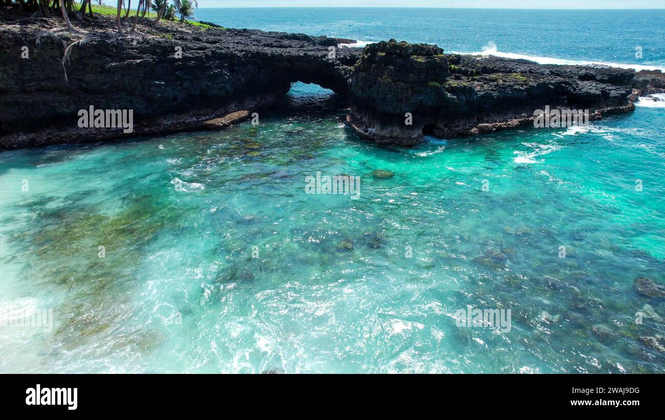 Ein malerischer Blick auf eine felsige Küste am Rande eines Sees mit Bäumen im Hintergrund, Sao Tome, Afrika Stockfoto